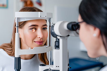 The image shows two photographs side by side on the left, a woman with a large eye patch over her eye is looking into an optical device, while on the right, another woman is examining the same device with a focused expression.