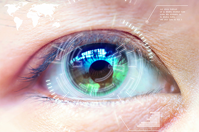 The image shows a close-up view of an eye with a digital overlay, displaying various electronic interfaces and circuit patterns around the iris.